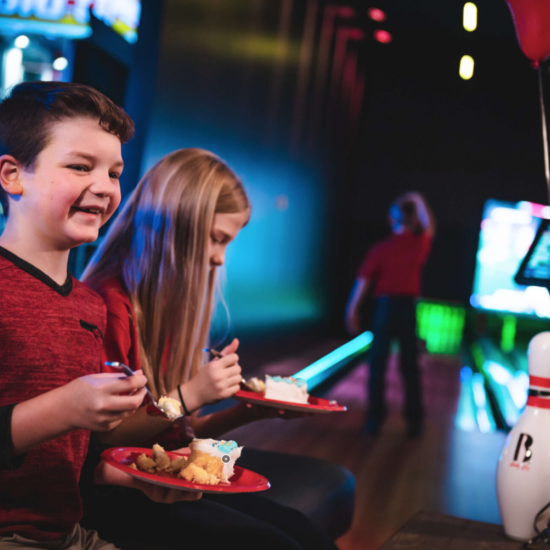 Two kids enjoy birthday cake at an Andy B's private event rental